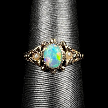 Close-up macro of late Victorian era 9k gold opal and seed pearl engagement ring on ring display