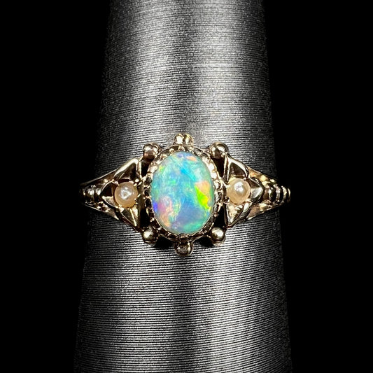Close-up macro of late Victorian era 9k gold opal and seed pearl engagement ring on ring display