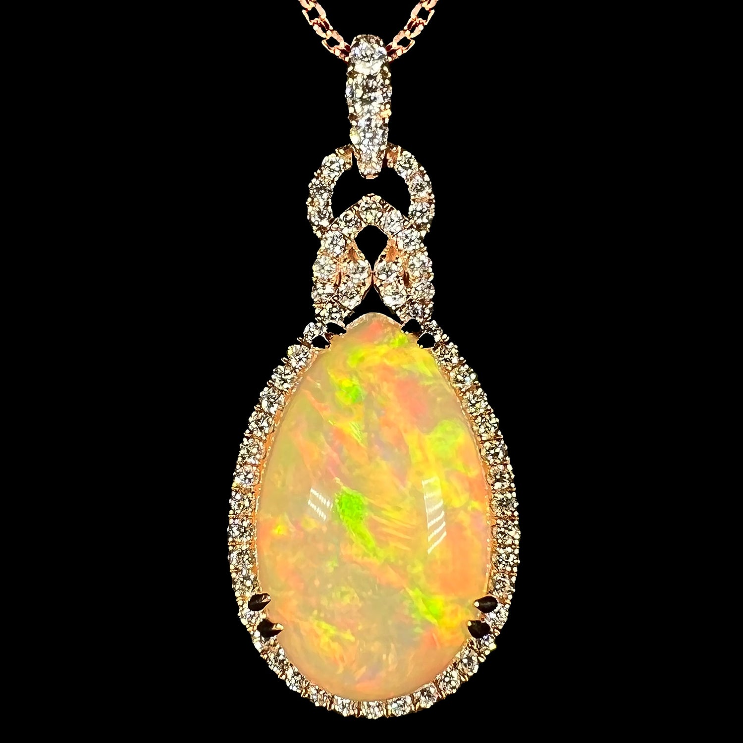 Front close-up view of a pear shaped 18k rose gold Ethiopian opal and diamond halo necklace by Le Vian, shown against a black background.