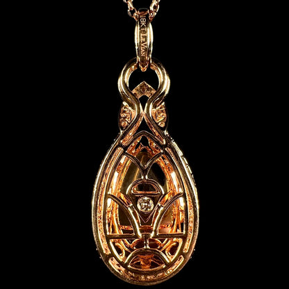 Back side of a Le Vian-designed 18k rose gold pendant, shown against a black backdrop.  A single diamond is seen set in the middle of the pendant.