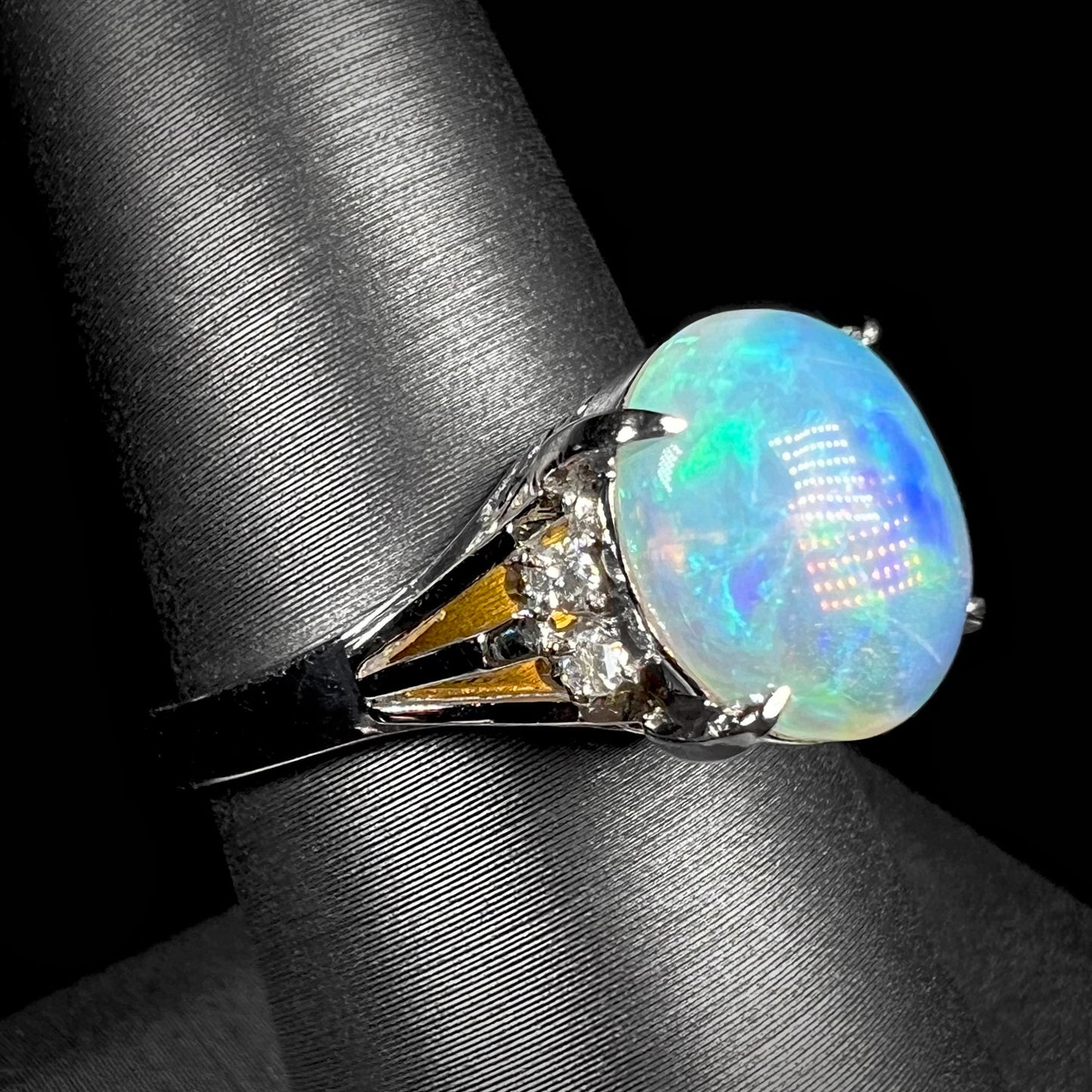 A platinum filigree ring set with a Lightning Ridge crystal opal and diamond accents.