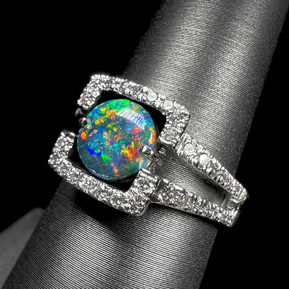 A square-shaped, diamond-accented engagement ring set with a round Lightning Ridge black opal.