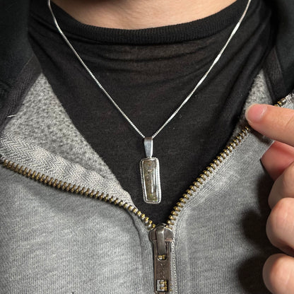 A Louisiana matrix opal necklace in sterling silver, worn around a neck and shown against a dark shirt.