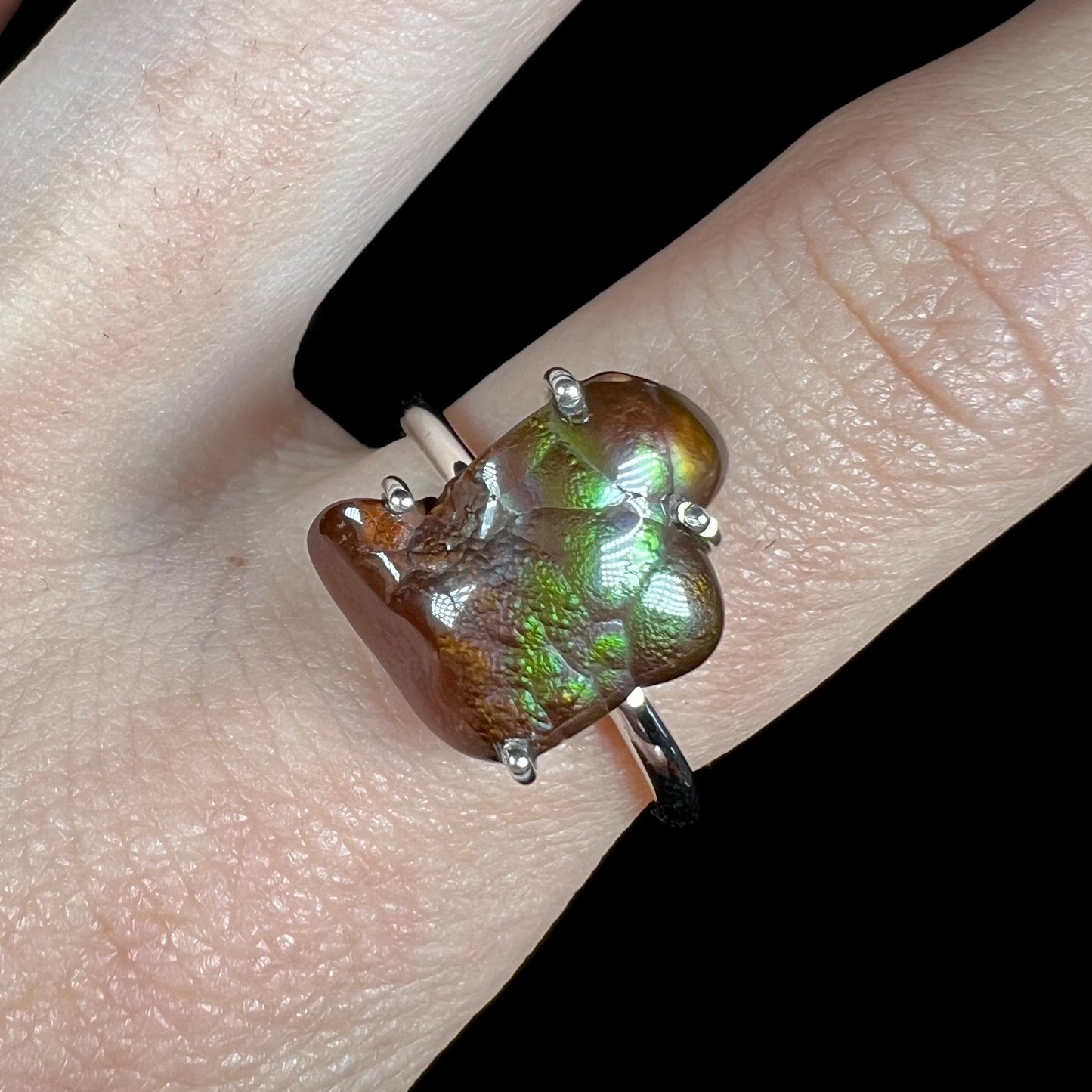 Macro view of green fire agate ring showing faint purple iridescence.