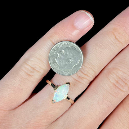 A marquise cut natural opal solitaire ring in yellow gold.