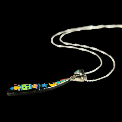 A men's sterling silver black onyx and opal inlay necklace with a Southwest-inspired motif shown from angle laying on black background.