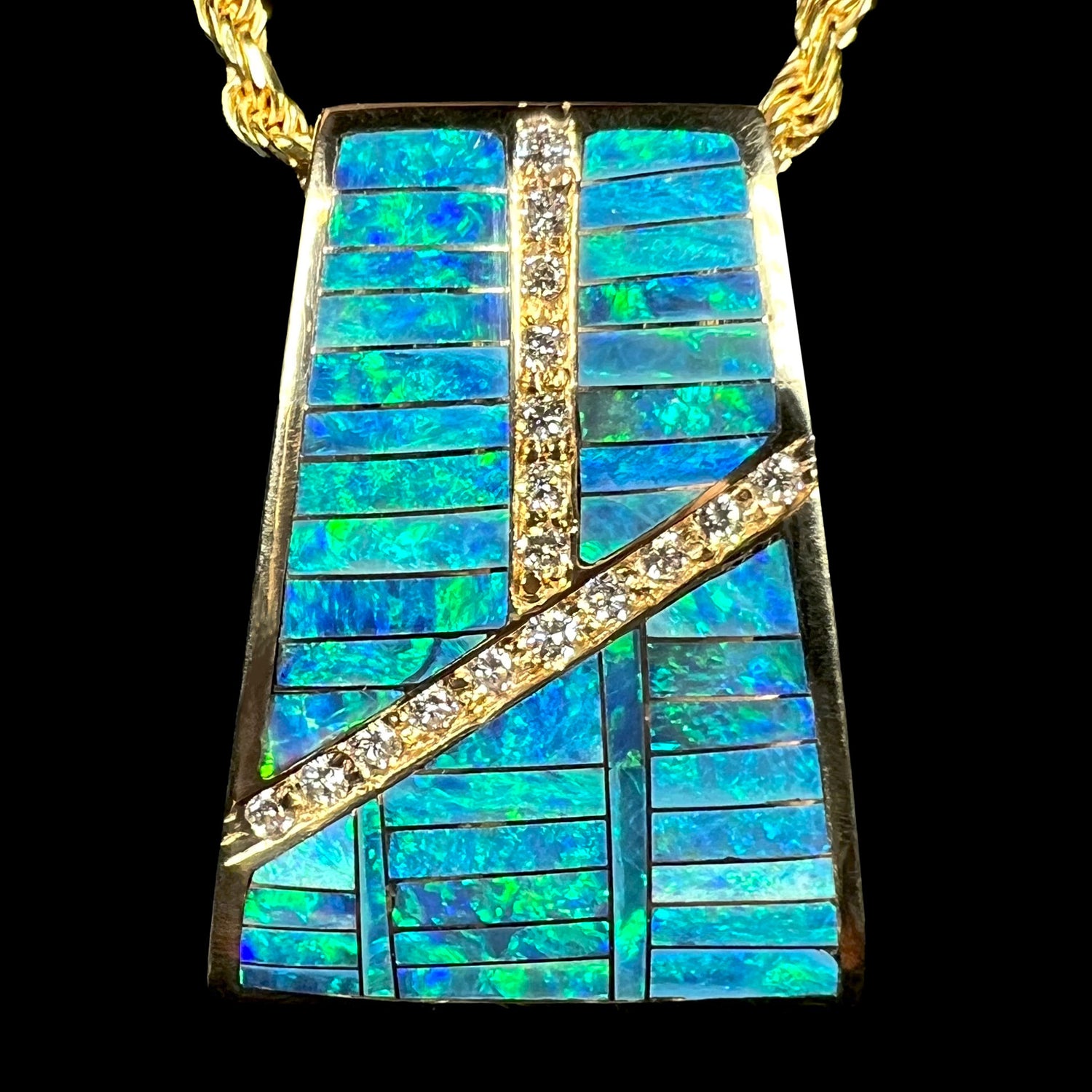 Front view of an 18k gold men's opal inlay pendant with diamond accents, shown on a rope chain against a black background.