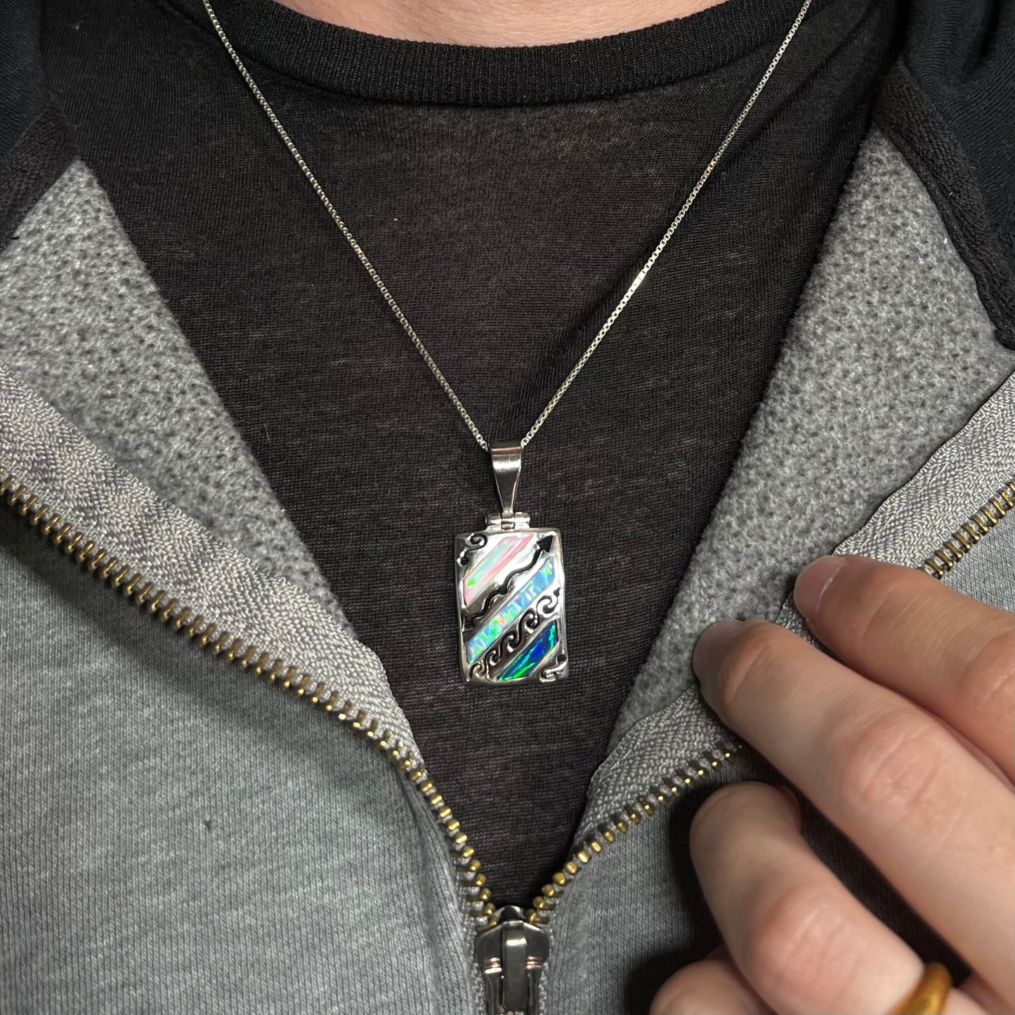 A men's 950 silver lab-created opal necklace, worn around a neck on a dark shirt.