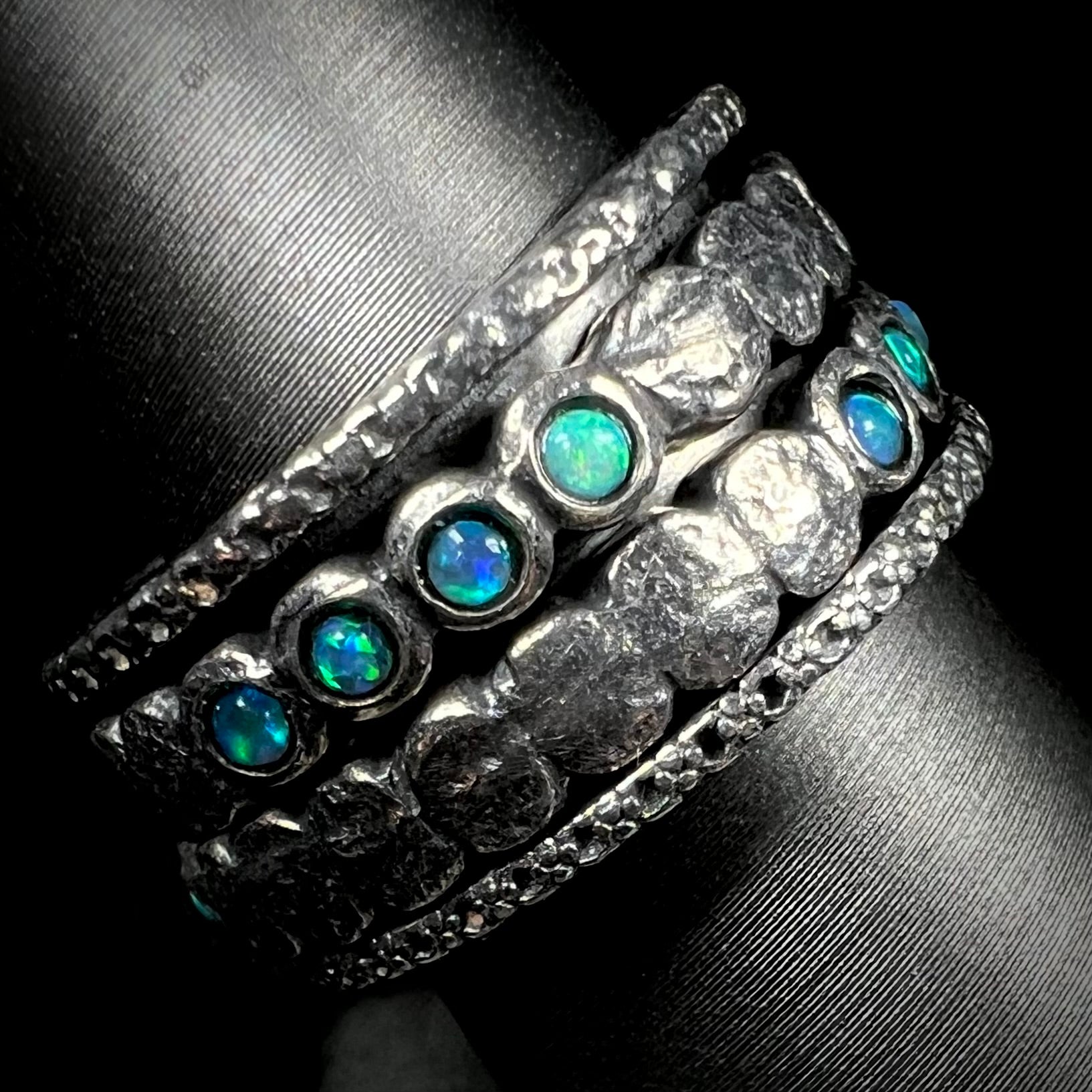 A men's opal spinner band made from sterling silver, shown from the side view.