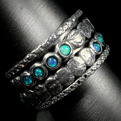 A men's opal spinner band made from sterling silver, shown from the side view.