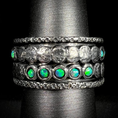 Men's ssilver opal spinner ring that measures 11.5mm wide, shown from the front against black background.