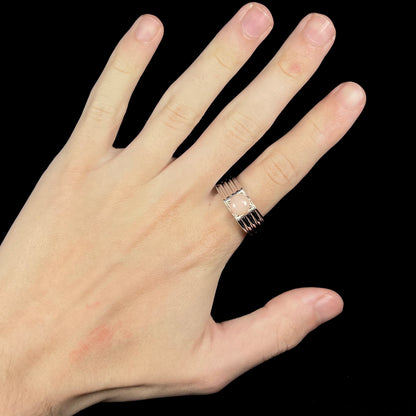 Hand wearing men's round pink Pervian opal ring made from sterling silver