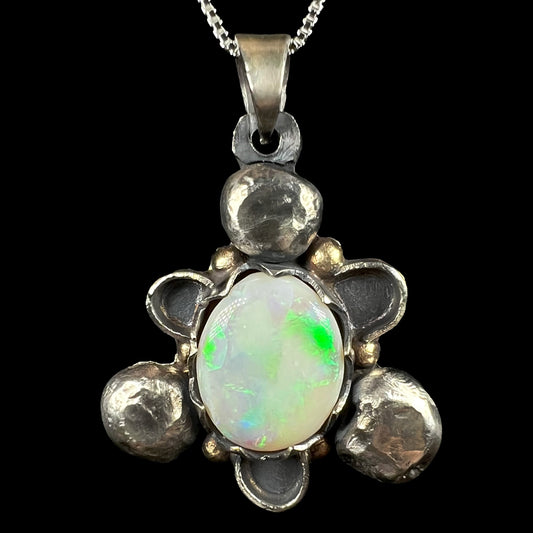 A men's rustic two-tone sterling silver and gold Australian opal pendant, shown close-up against black.