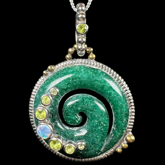 A men's carved green aventurine koru spiral pendant with peridot and opal accents, shown on a black background.