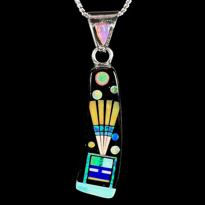 Macro front view of men's sterling silver Southwest-style stone inlay pendant with opal accent shown on black background.