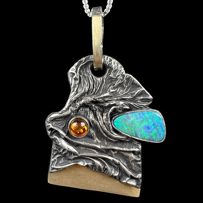 Front close-up of a men's two-tone sterling silver and 18k gold brutalist-style opal doublet and amber pendant by Starborn Creations.