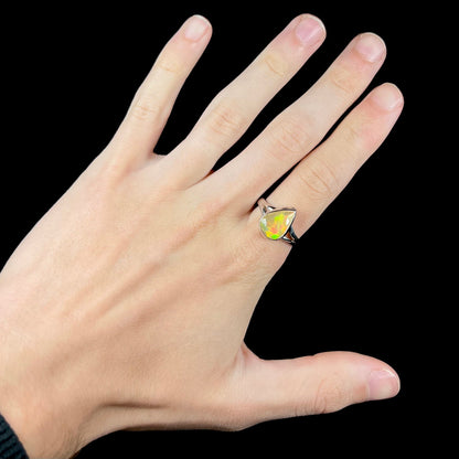 A unisex sterling silver ring set with a faceted pear shaped Ethiopian fire opal.  The opal plays orange, red, and green colors.