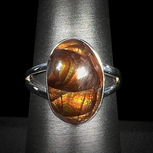 Close-up of silver Mexican fire agate ring with split shank, shown from the front view against black background.
