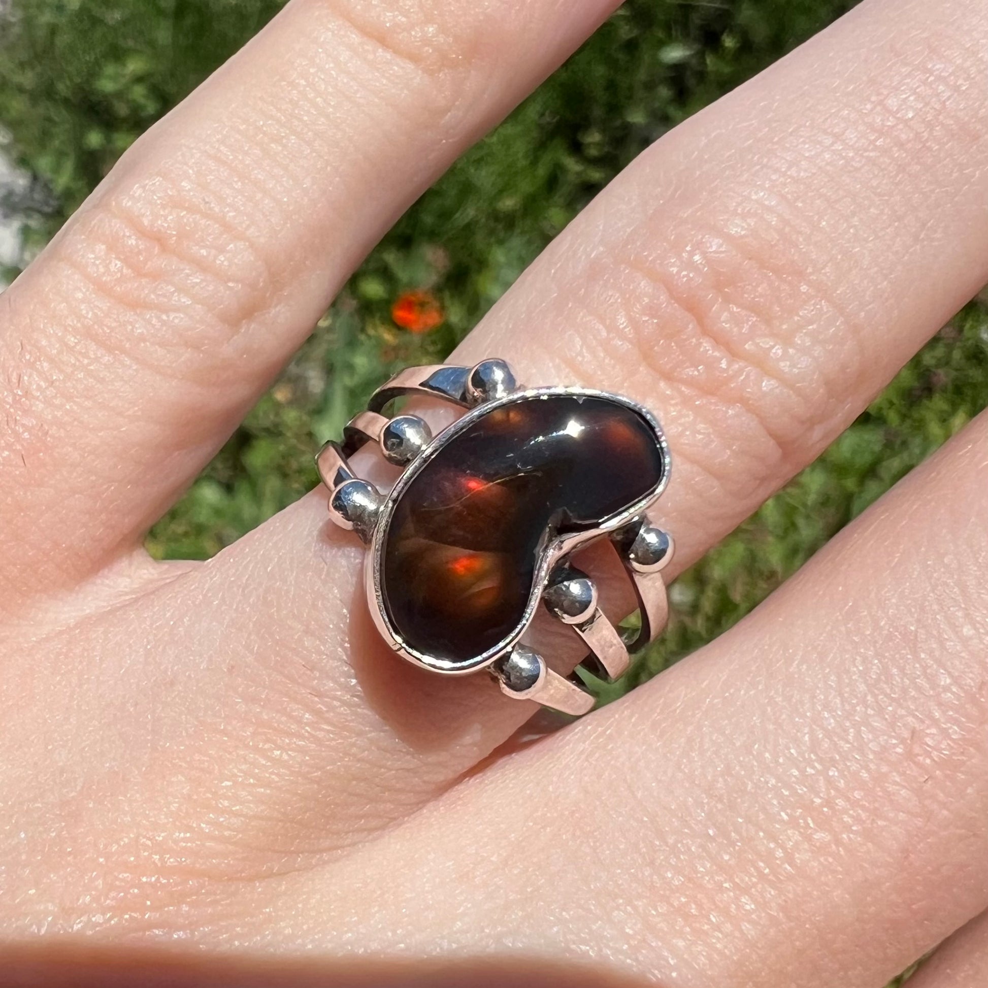 Macro view of reddish brown fire agate ring in outdoor lighting.