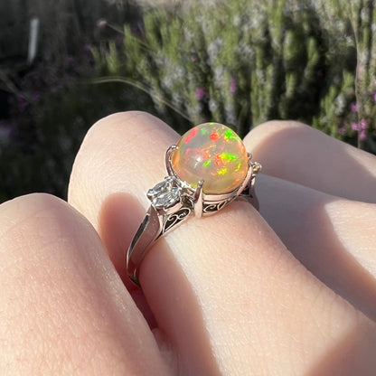 A platinum and diamond-accented Mexican fire opal ring with vibrant red and green play-of-color.