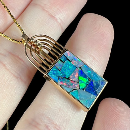 Angled macro shot of a mosaic opal necklace, with a bright green flash visible in the opal.