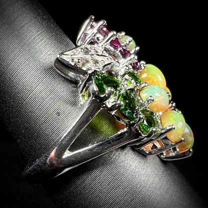 Side close-up view showing silver split shank of a multi-gemstone flower ring.
