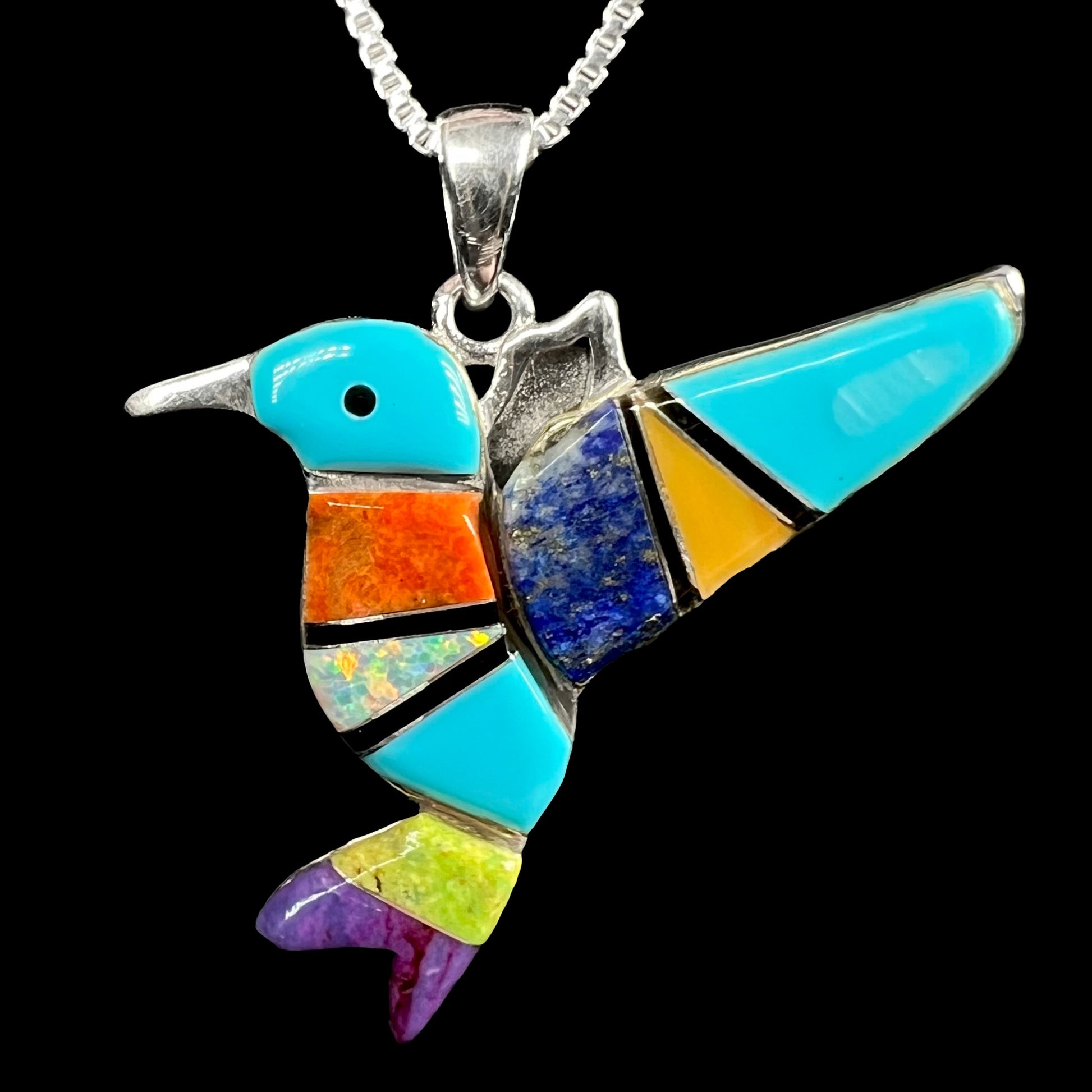 A multi-stone turquoise & opal inlay hummingbird necklace in sterling silver, shown against a black background.