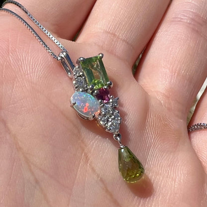 Macro angled view of a multistone cluster pendant held in the sunlight.