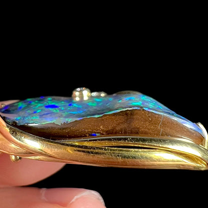 Side profile view of Australian boulder opal pendant showing the opal's natural, imperfect ironstone matrix seam.