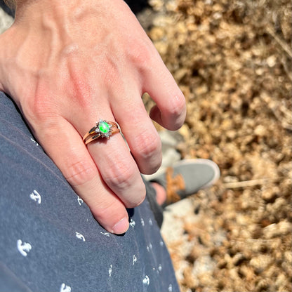 Hand resting on person's hip in sunlight wearing natural green Australian opal and diamond ring in 14k gold