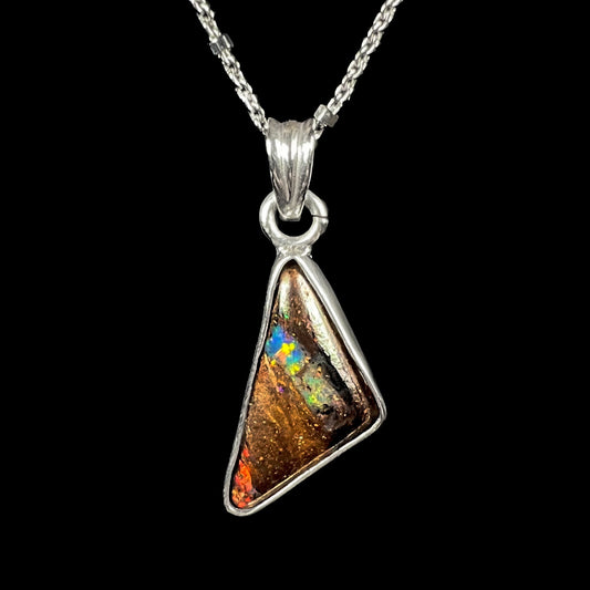 A triangle shaped opal necklace in sterling silver.  The opal shines with every color of the rainbow.