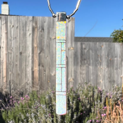 A macro outdoor close-up of the Navajo inlay pendant, showing the opal side.