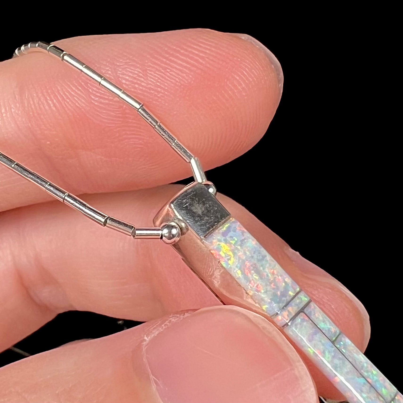 A macro close-up of the front of the Navajo inlay pendant, highlighting visible silver stains.