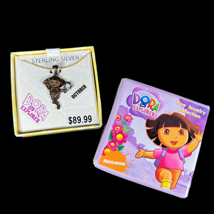 Dora the Explorer Fine Jewelry Collection gold-plated sterling silver opal necklace in Nickelodeon box on back background.