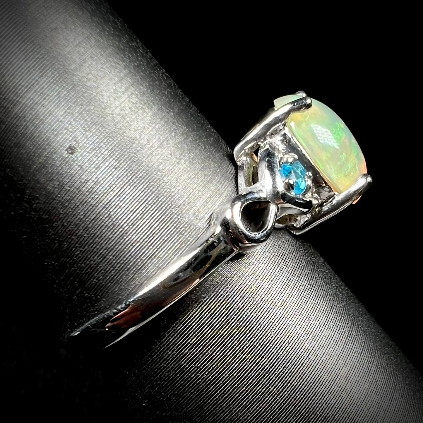 Side view of opal and blue apatite ring in sterling silver on ring display