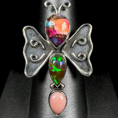 A sterling silver butterfly ring set with lab-created and pink Peruvian opals, shown from the front.