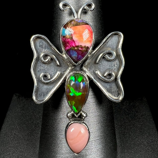 A sterling silver butterfly ring set with lab-created and pink Peruvian opals, shown from the front.