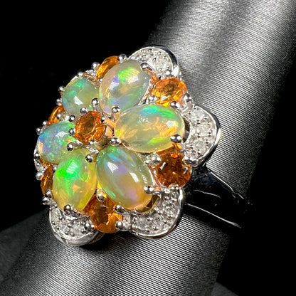 Angled view of a silver opal cluster flower ring set with diamond accents.