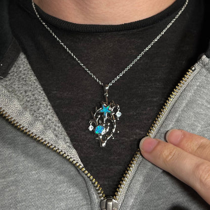 A silver plated coral reef necklace with blue lab-created opal inlay and CZ accents worn around a neck.