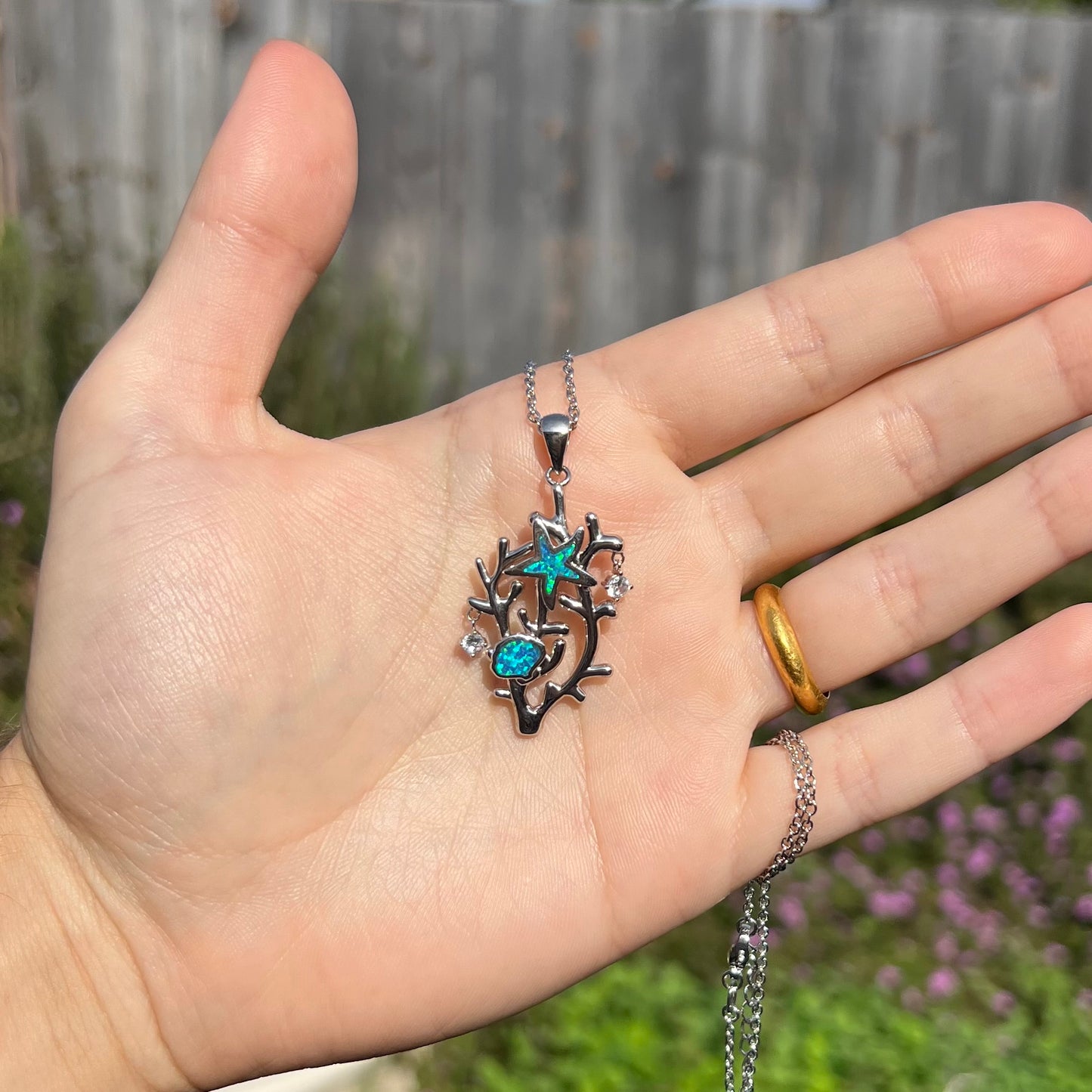 A silver plated coral reef necklace with blue lab-created opal inlay and CZ accents.