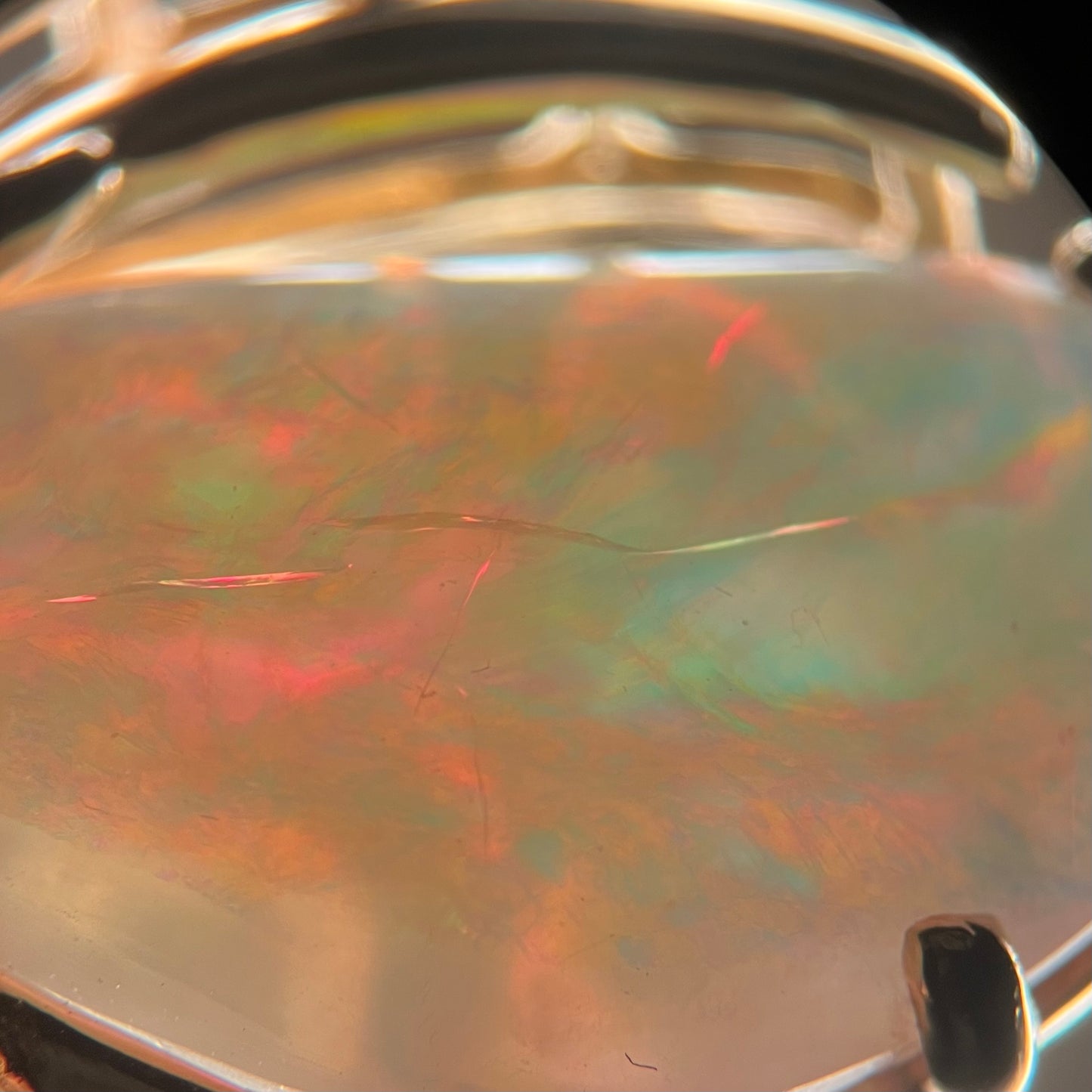 Crazing seen in a backlit Australian opal under a microscope.  Multiple cracks run into one another beneath the opal's surface.