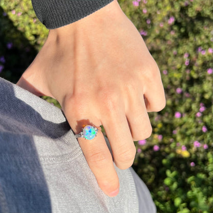 A platinum filigree ring set with a Lightning Ridge crystal opal and diamond accents.