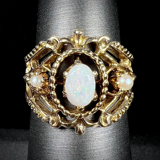 A Victorian-style yellow gold opal ring mounted with two seed pearl accents.