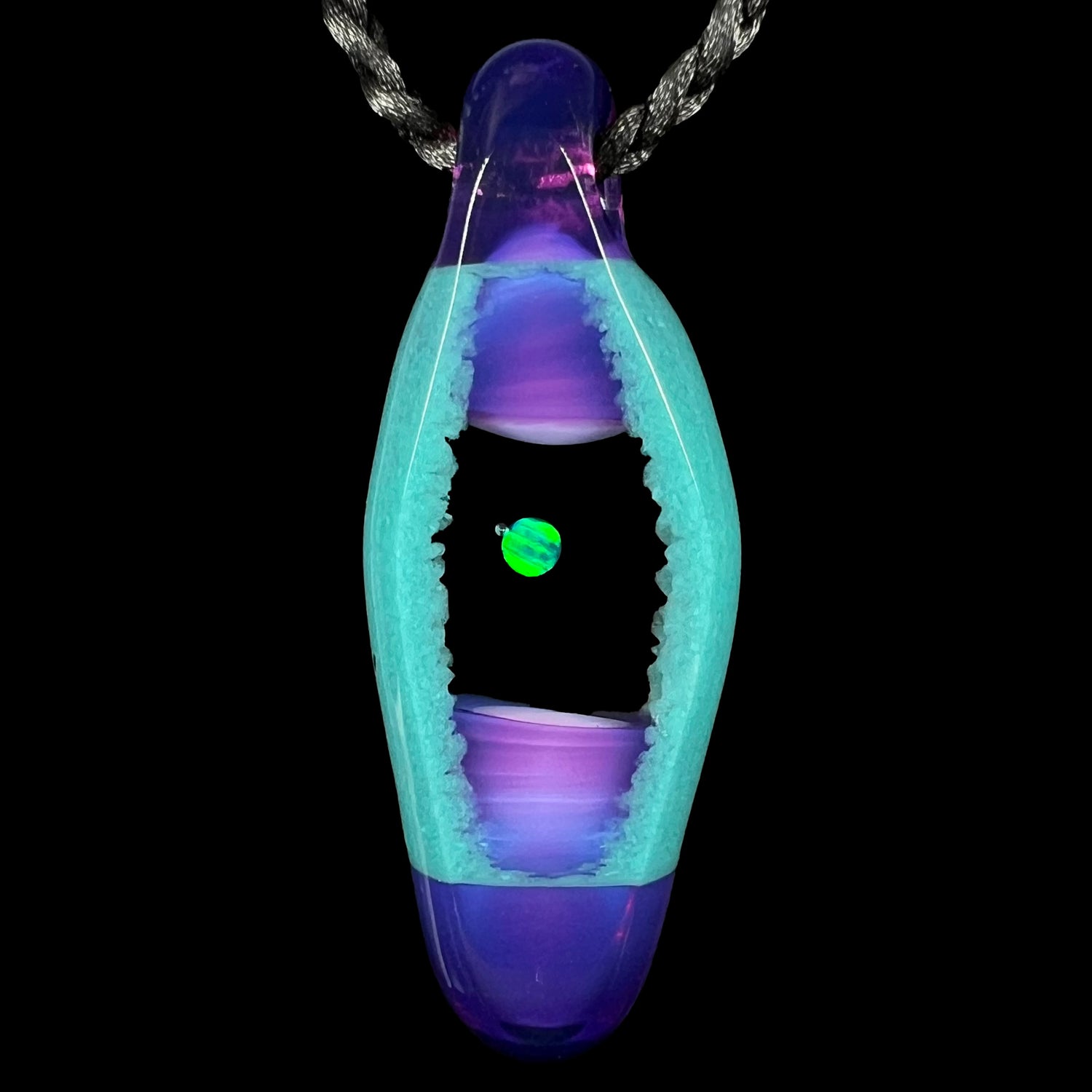 A unisex lab-created opal and boro glass pendant by artist, Nathan Snyder, from his 'Opal Geode' pendant line, shown against a black background.