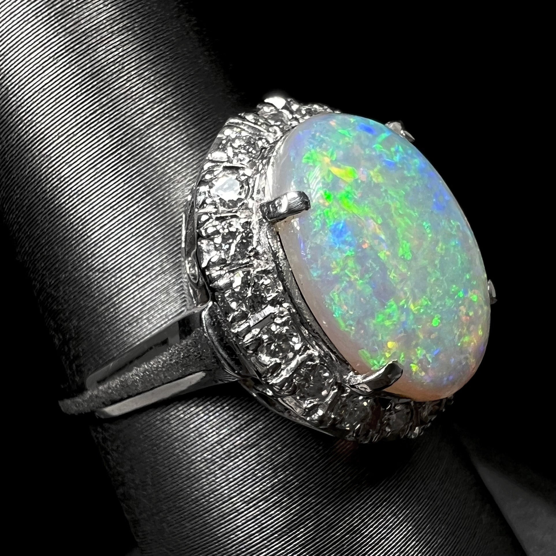 A vintage platinum opal engagement ring.  The ring has a diamond halo around the opal.