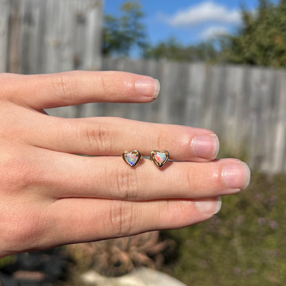 Yellow gold natural opal heart stud earrings.  The earrings have bright red and blue colors.