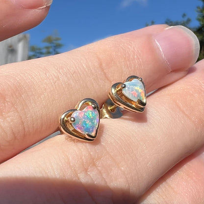 Yellow gold natural opal heart stud earrings.  The earrings have bright red and blue colors.