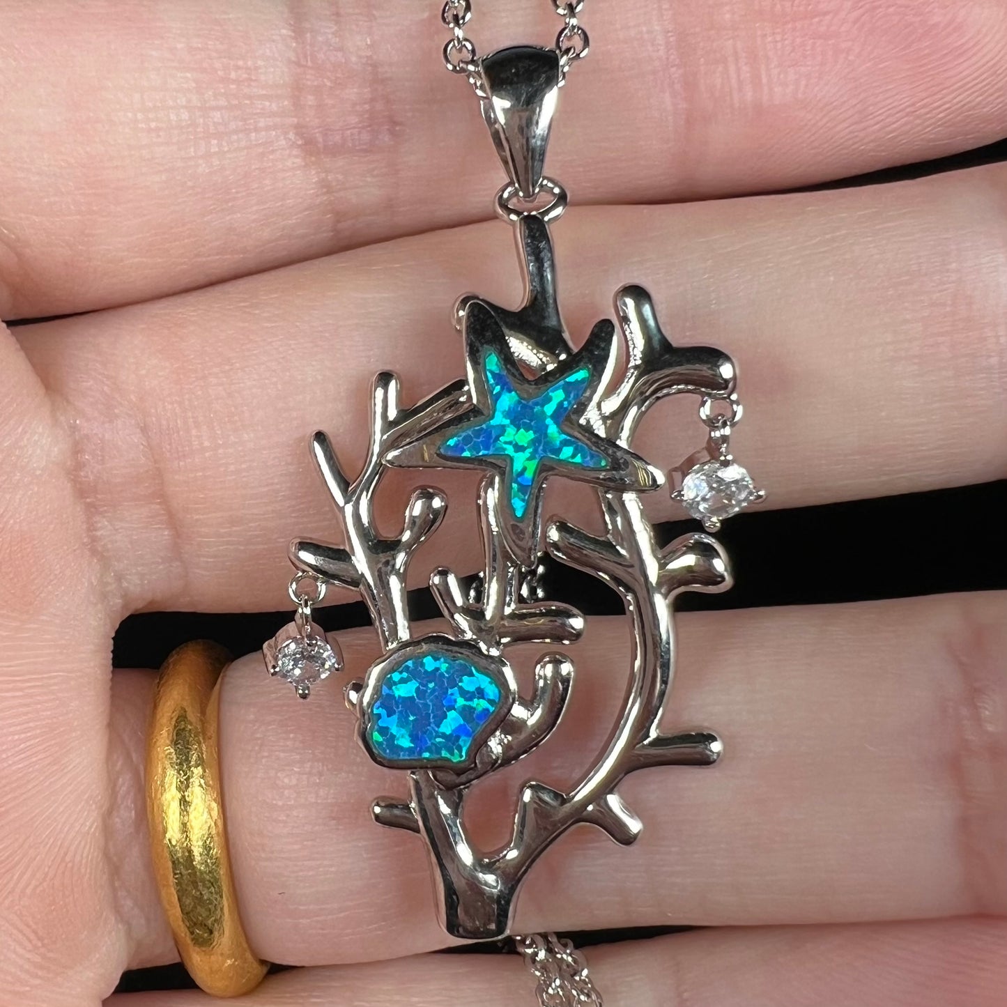 A silver plated coral reef necklace with blue lab-created opal inlay and CZ accents.
