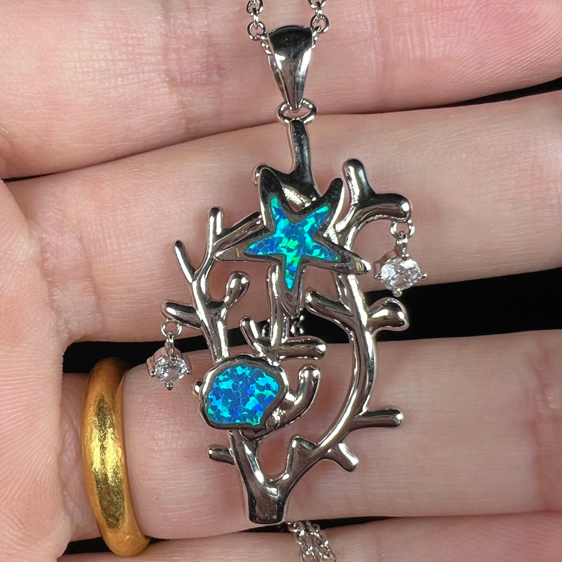 A silver plated coral reef necklace with blue lab-created opal inlay and CZ accents.