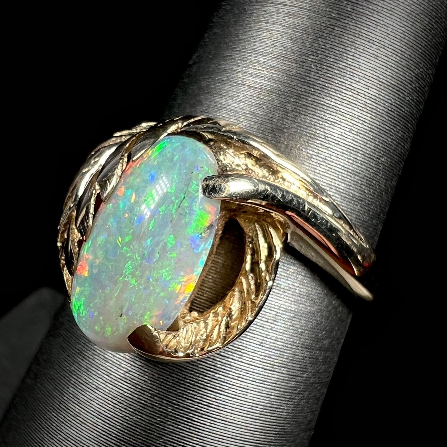 A green Coober Pedy opal set in a gold leaf ring.